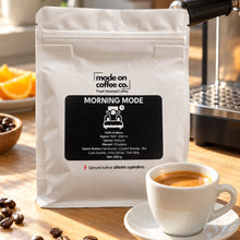 Görseli Galeri görüntüleyiciye yükleyin, Morning Mode Etiyopya kahve paketi ve kremalı espresso, güneşli mutfakta ev tipi espresso makinesi yanında
