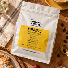 Görseli Galeri görüntüleyiciye yükleyin, Brezilya Yellow Bourbon – Filtre ve Espresso Kahve – kahve paketi, kruvasan ve kahve çekirdekleriyle masada – Mode On Coffee Co.
